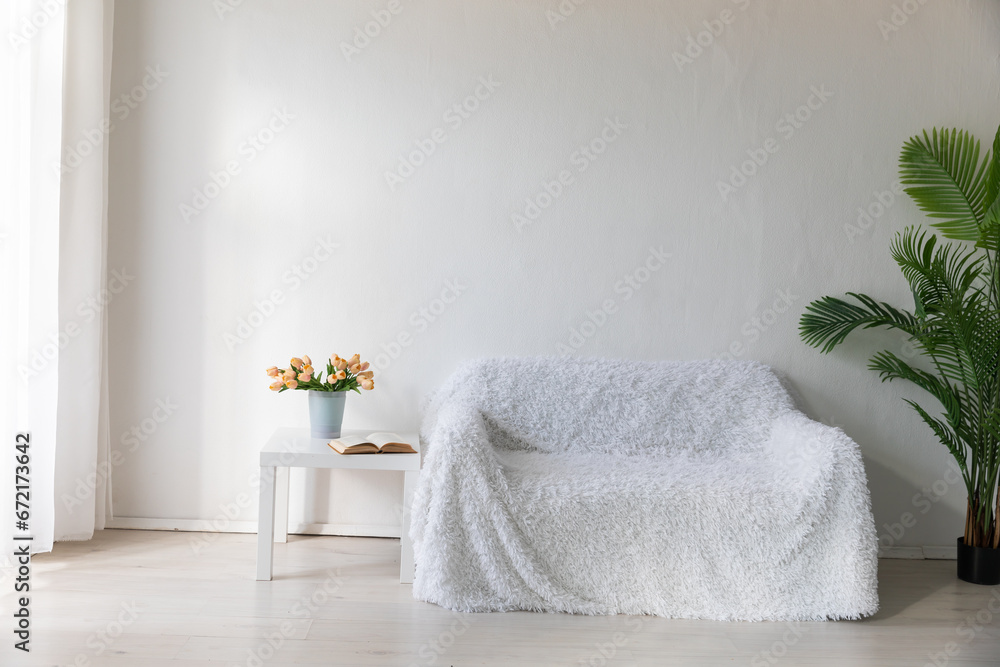 Interior of a white room with a sofa with flowers Interior of a white room with a sofa with flowers