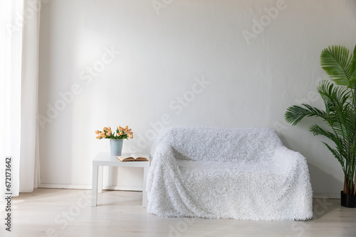Fototapeta Naklejka Na Ścianę i Meble -  Interior of a white room with a sofa with flowers