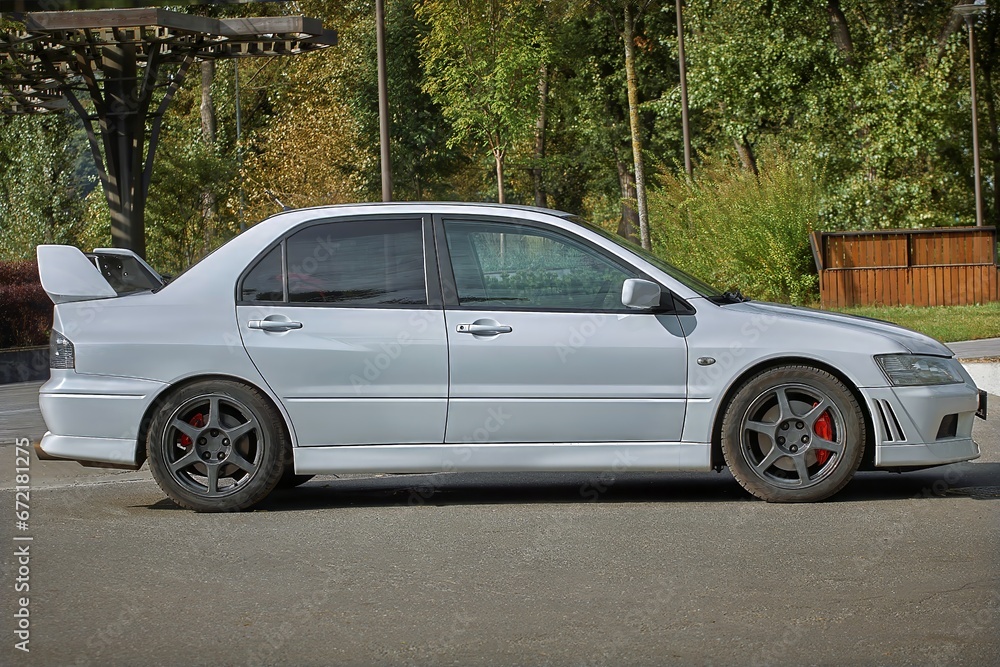 White car on a street background. Modern city sport car with a spoiler wallpaper