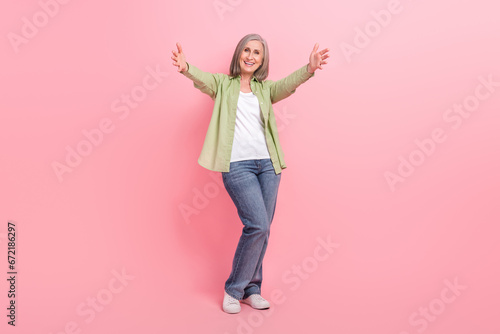 Full length photo of kind lovely friendly senior lady wear trendy clothes open arms glad see you isolated on pink color background photo