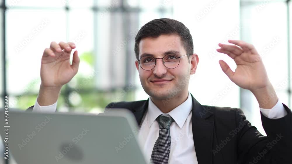 business man holding his hands behind his head while working on a laptop business man holding his hands behind his head while working on a laptop