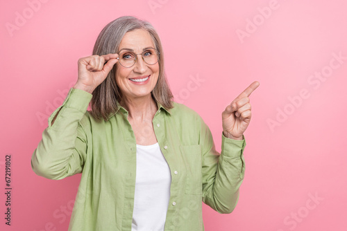 Photo of grandmother teach create wikipedia page for free touch her spectacles direct finger empty space isolated on pink color background photo