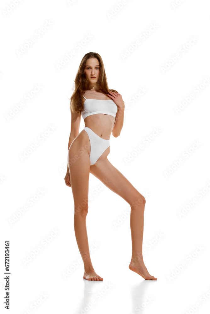 Full length portrait of beautiful fit woman posing in white lingerie showing her ideal curves isolated studio background. Full length portrait of beautiful fit woman posing in white lingerie showing her ideal curves isolated studio background.