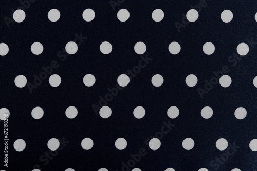 Black fabric texture with white polka dots close-up. background for your design. Material for sewing clothes and dresses