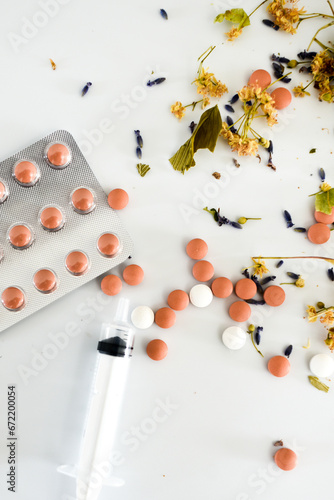 Medicine, pills and linden flowers on a white background, natural medicine vs synthetic