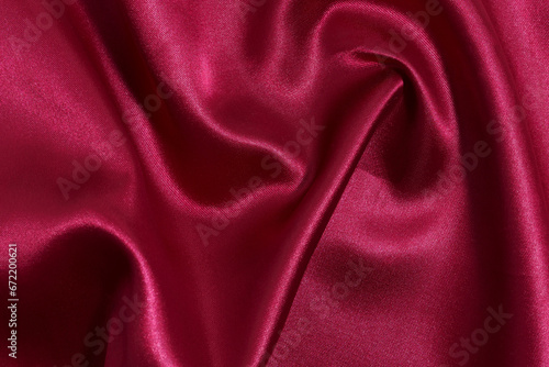 Texture of crumpled, wrinkled fabric of red color with shine close-up. Luxury background for your design. Materials for sewing
