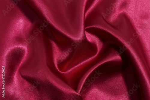 Close-up texture of red crumpled fabric of red or burgundy color. Sewing material. Elegant background for your design