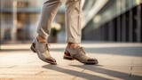 Urban Footwear Fashion: A stylish man puts his leg on the city pavement, highlighting contemporary suede shoes and modern street style