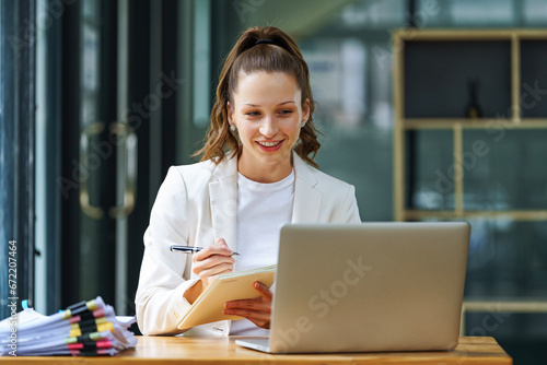 A businesswoman writes in a notebook or plans a schedule or agenda for project management in the office. Employee, manager, or corporate worker with research for strategy innovation ideas.