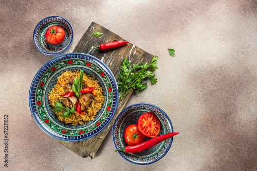 tasty Asian pilaf in plate with oriental ornament, Uzbek oriental cuisine on a light background top view. place for text