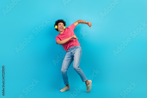 Full body photo of handsome young male dancer earphones have fun wear trendy pink outfit isolated on blue color background