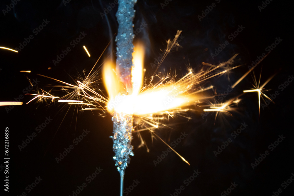 sparks from a burning sparkler on a black background.