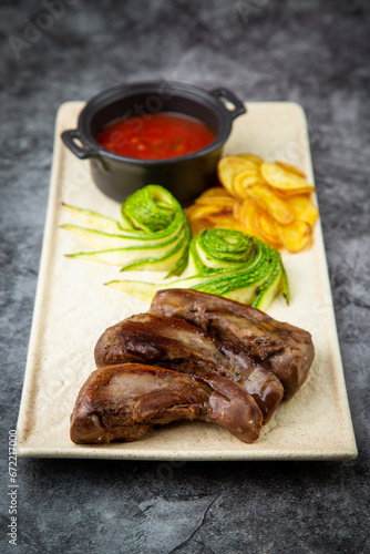 side view of meat ribs with avocado, chips and ketchup on a white plate