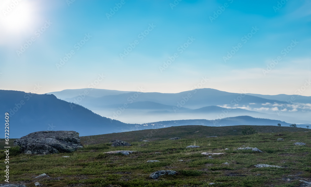 Early in the morning up in the mountains of Tänndalen in Sweden. A beautiful blue sky and morning mist still lingering down in the valley. Early in the morning up in the mountains of Tänndalen in Sweden. A beautiful blue sky and morning mist still lingering down in the valley.