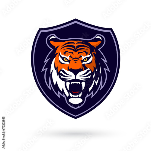 Fototapeta Naklejka Na Ścianę i Meble -  This fierce and powerful tiger mascot head logo, set within a shield, represents strength and competitiveness. Perfect for esport and gaming teams, it features a white backdrop for versatility