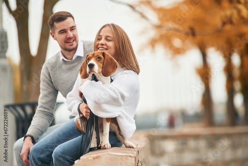 Lovely couple are with their cute dog outdoors photo