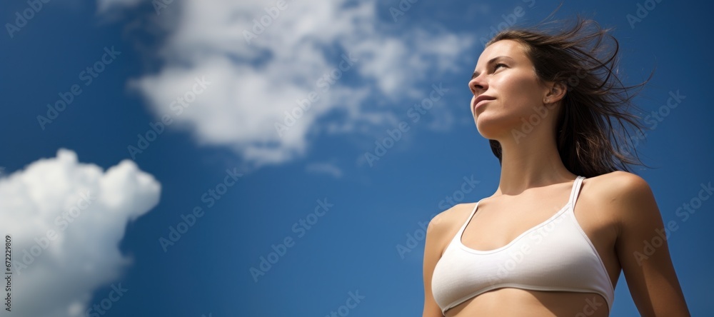Woman looking at sunny blue sky