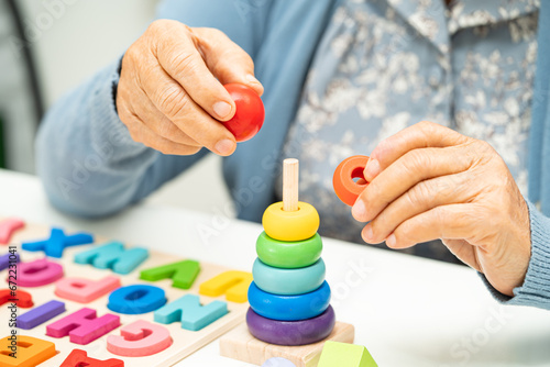 Alzheimer disease AD, Asian elderly woman patient suffering from dementia learn practical motor skills rehabilitation.