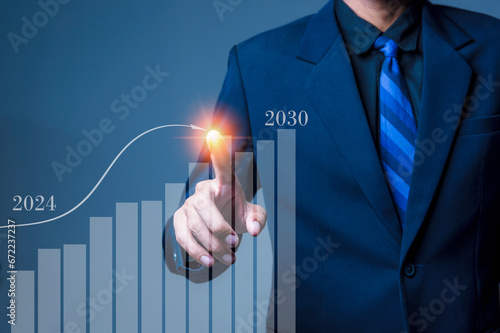 Growth 2024 concept. Businessman's hand planning growth and increasing positive indicators in his business, strategy to 2030.