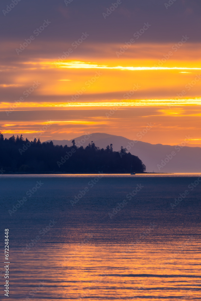 Dramatic colorful sunset over freighter ships in English Bay and Burrard Inlet, seen from Stanley Park