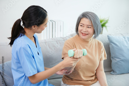 nurse or caregiver helping elderly woman to physiotherapist and exercise for rehabilitation at home