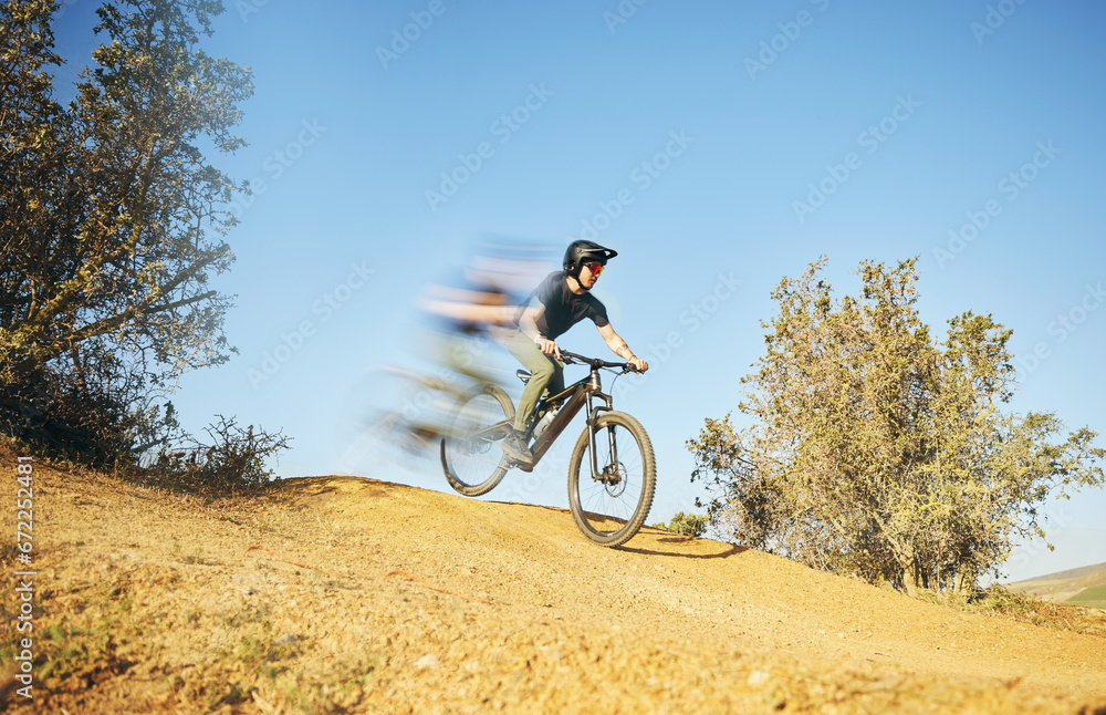 Naklejka premium Mountain bike, downhill and man outdoor in nature for extreme sports or fast training. Blur motion, speed and male person with courage or bicycle stunt for off road cycling, travel or adventure