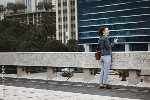 Business woman, rooftop and thinking with phone, vision and planning for future, career on ideas for goal. Entrepreneur, dream and brainstorming with smartphone for choice, decision or mindset in cbd