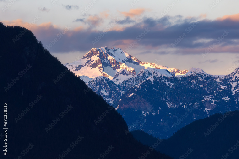 Obraz premium Golden sunset light hitting snow capped mountain peaks in Golden Ears Provincial Park. Maple Ridge, British Columbia