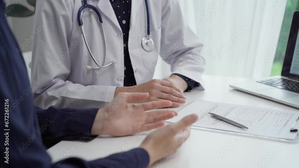 Doctor and patient sitting at the table and discussing something. The pediatrician in a blue dotted blouse and white medical coat is gesturing actively. Medicine concept Doctor and patient sitting at the table and discussing something. The pediatrician in a blue dotted blouse and white medical coat is gesturing actively. Medicine concept