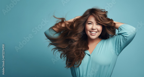 Beautiful happy woman model posing touches hair on blue background