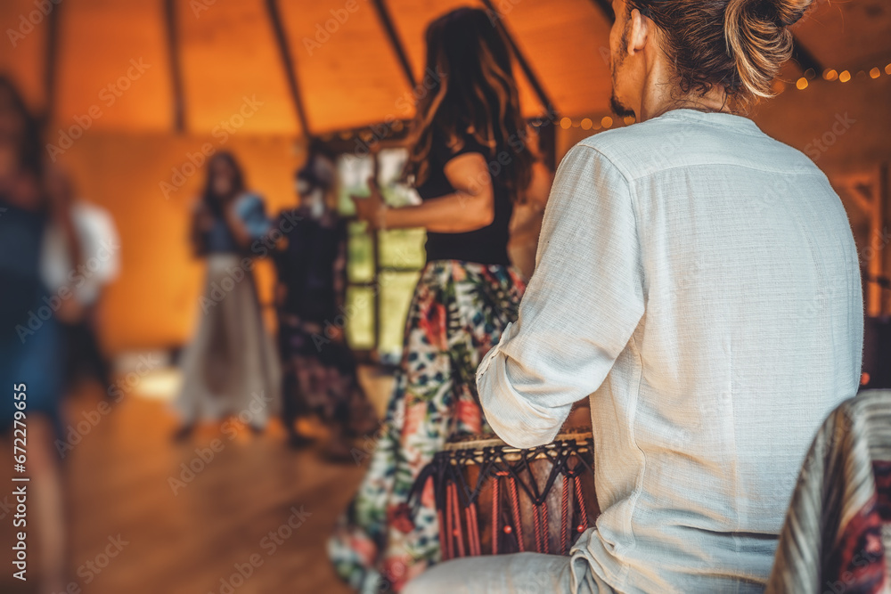 Drummer playing the djembe at the cacao ceremony. Ceremony dance in circle. Ceremony space.