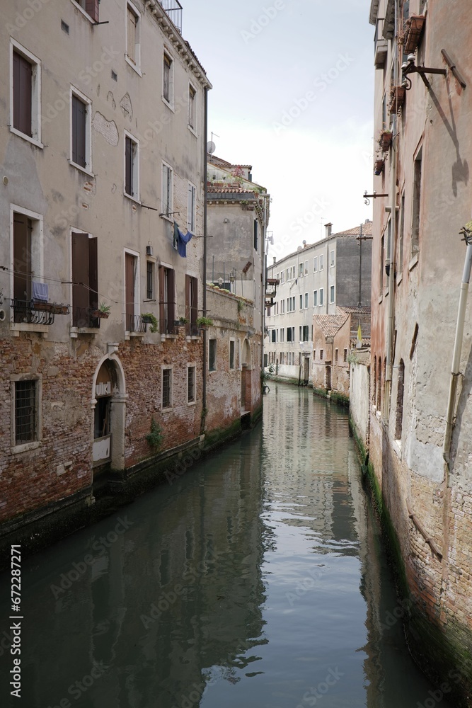 Tranquil urban scene with a river with tall buildings in the background in Venice