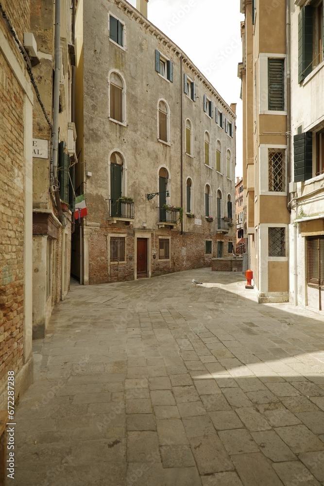 Bustling Italian cityscape with narrow, cobblestone streets lined with buildings in  Venice