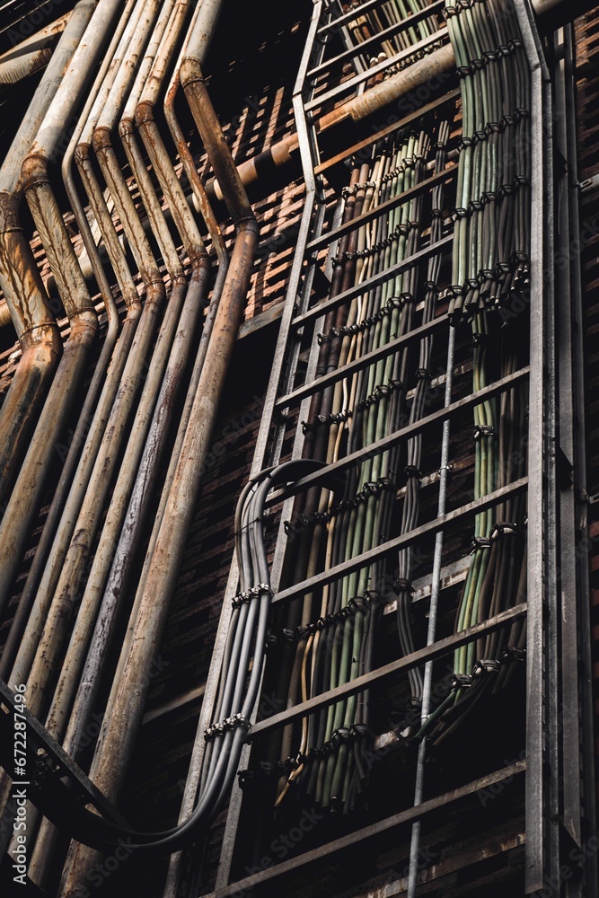 Obraz premium Industrial construction featuring multiple silver pipes and electric cables