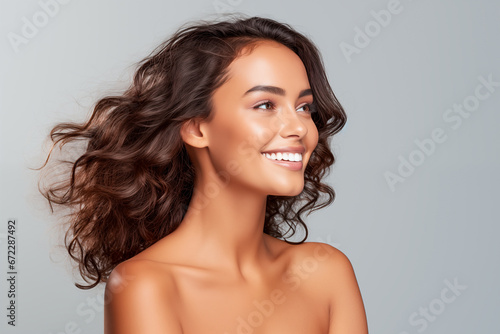 Multiracial beauty model smiling in front of gray background with copy space. Skincare and beauty.
