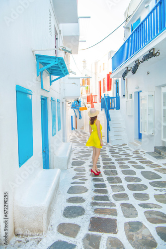 Woman in yellow dress at the Streets of old town Mykonos during a vacation in Greece, Little Venice Mykonos Greece © Kyrenian