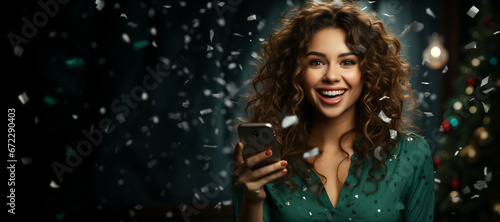 cheerful woman with a large mobile phone, under confetti, rejoices about winning