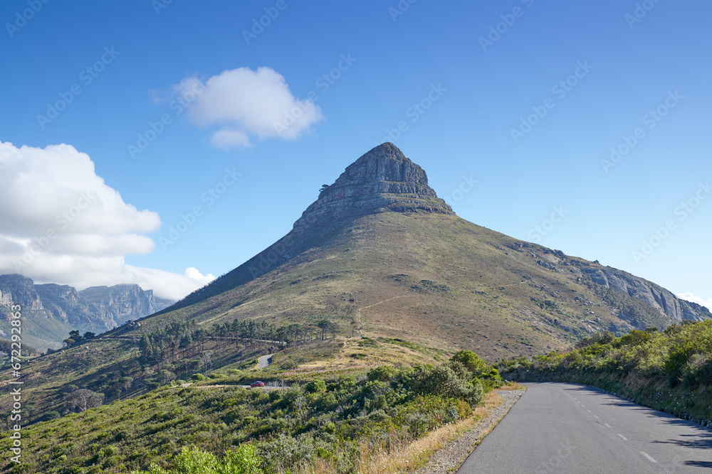 A road leading to Lions Head in Cape Town, South Africa against blue sky copyspace on a sunny morning. A highway along a peaceful mountain landscape with scenic views or lush green bushes and trees