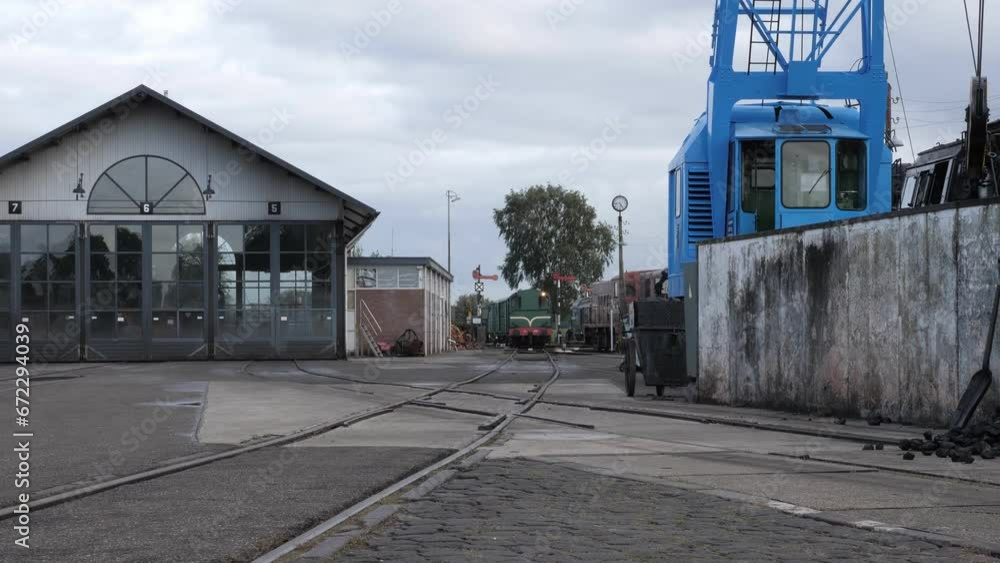 Marshalling area on old railroad train station with vintage blue crane and train shed Marshalling area on old railroad train station with vintage blue crane and train shed