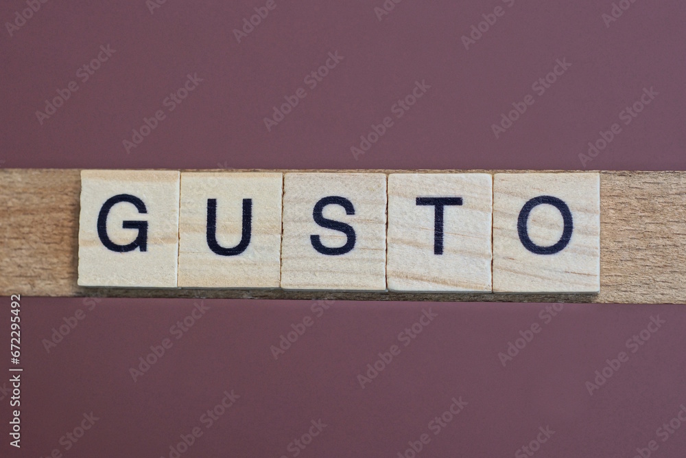 gray word gusto made of wooden square letters on brown background gray word gusto made of wooden square letters on brown background