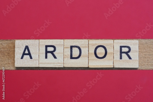 text the word ardor from gray wooden small letters with black font on an red table