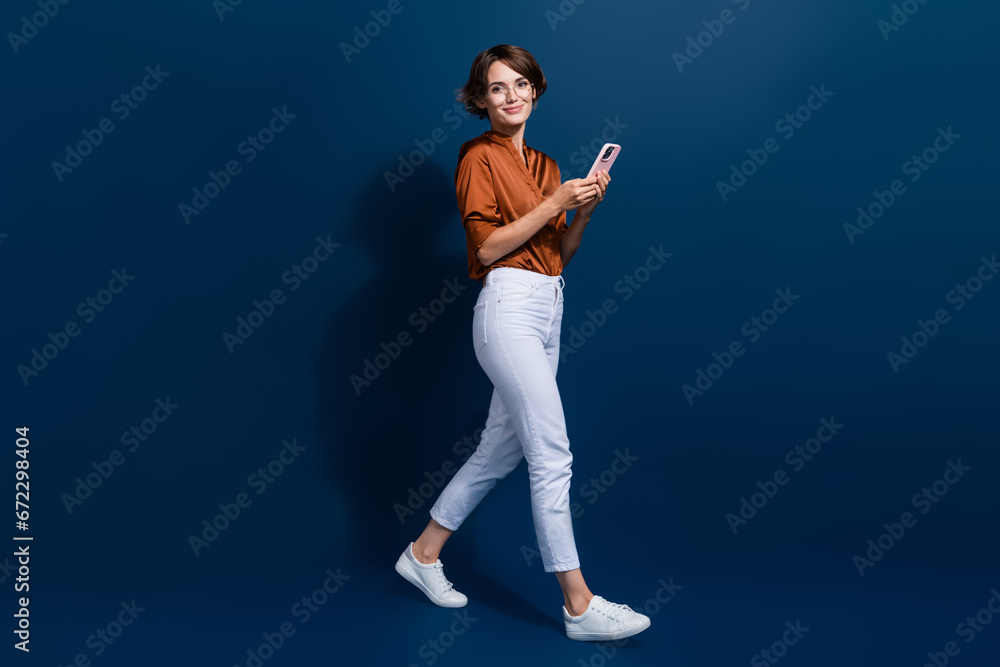Full length photo of shiny cute girl dressed brown shirt chatting instagram twitter telegram facebook isolated blue color background