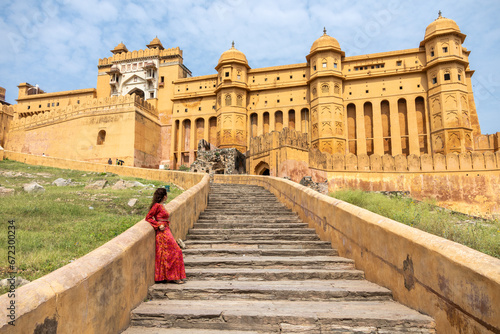 Woman at the entrance to Amber Fort in daytime with cloudy sky, near Jaipur, The Pink City, Rajasthan, India