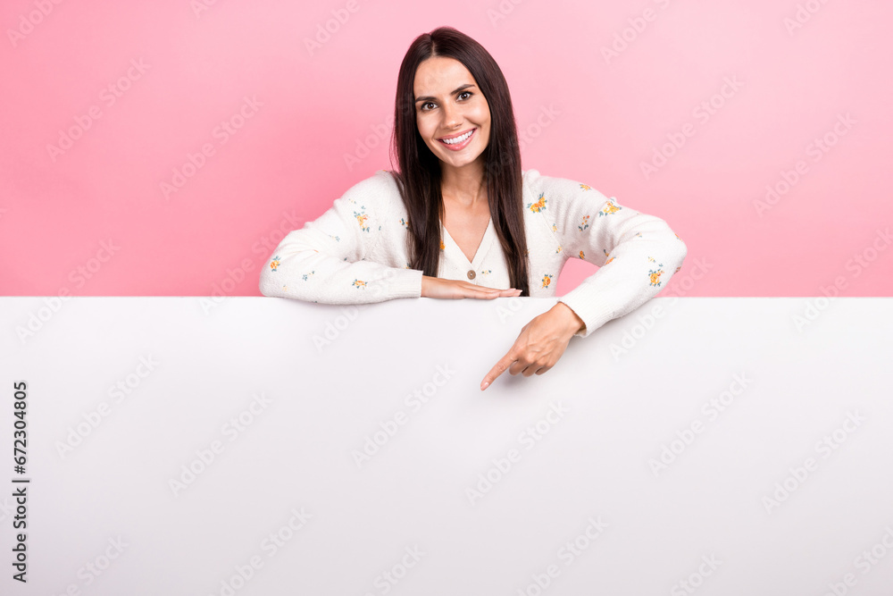 Photo of cute positive woman dressed white shirt pointing finger white placard empty space isolated pink color background Photo of cute positive woman dressed white shirt pointing finger white placard empty space isolated pink color background