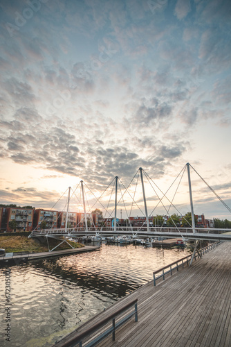 Pedestrian and bicycle bridge over the harbour in the centre of Almere during sunset. Dutch modern and utilitarian construction