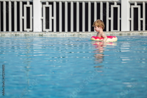 Little boy or kid with rubber inflatable circle swimming in resort shallow pool during vacation. © shine