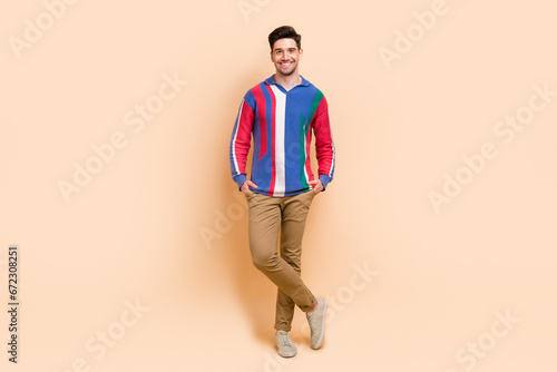Full length photo of optimistic young cheerful businessman put hands into pockets casual style clothing isolated on beige color background