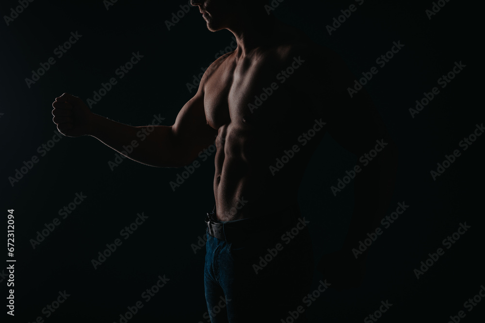 Obraz premium Silhouette photo of fit male sports person showing his biceps, triceps, flexing his muscles. Sport, workout motivation concept