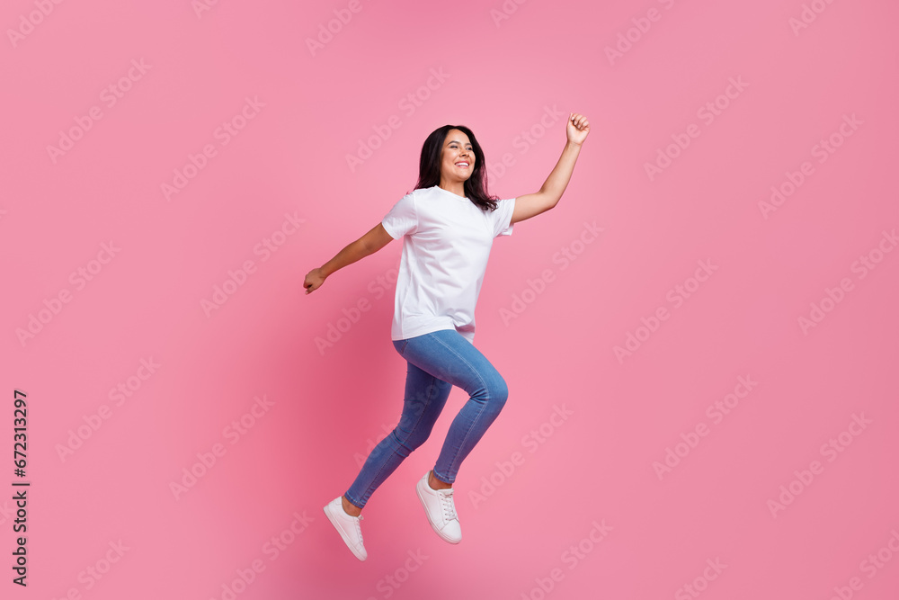 Full body length photo of running young funky girl sportswoman enjoy doing exercises in air isolated on pastel pink color background