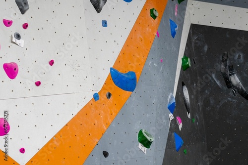 Indoor colorful climbing wall, featuring a variety of hand-holds and footholds photo